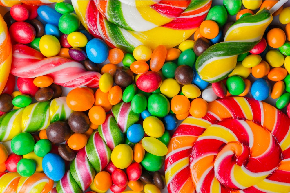 Assortment of colorful candies and lollipops, representing sugary foods that cause inflammation.